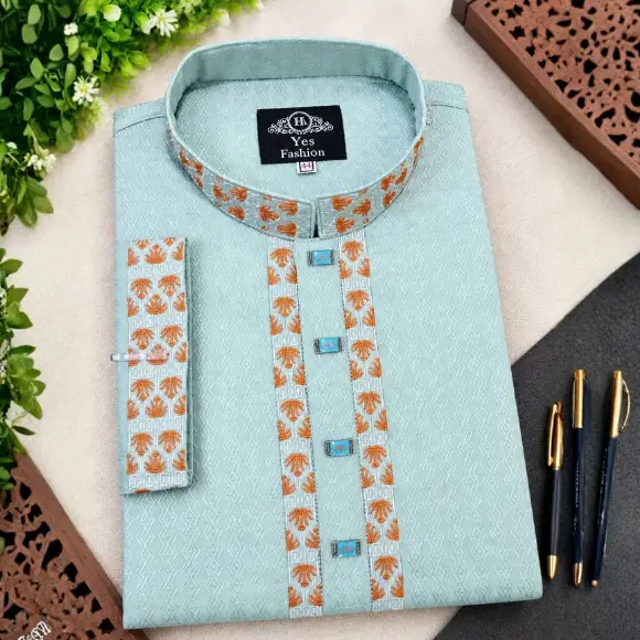 Light green Indian Cotton men's panjabi with orange and white palm pattern embroidered collar and placket, light blue square buttons, displayed in a styled setup